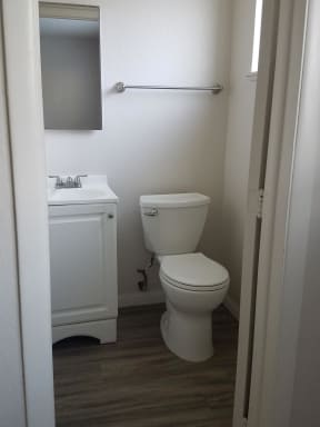 Bathroom with white cabinets and fixtures at Tulip Street Apartments in Escondido, California.