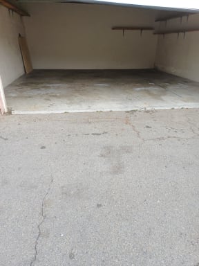 Wide garages with wall shelves at Juniper Street Apartments in Escondido, California.