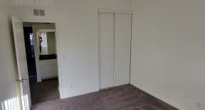 Carpeted bedroom with large closet at Northwood Apartments in Upland, California.