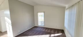 Carpeted living room with lots of natural light in one-bedroom unit at Northwood Apartments in Upland, California.