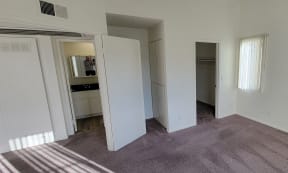 Large bedroom with walk-in closet, storage cabinets and bathroom at Northwood Apartments in Upland, California.