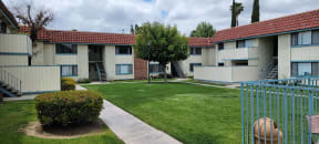 Private patios and balconies around grassy courtyard and pool at Magnolia Apartments in Riverside, California.