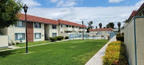 Gated swimming pool and grassy courtyard at Magnolia Apartments in Riverside, California.