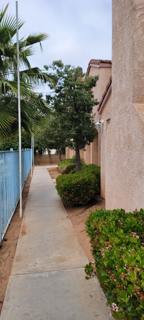 Walkway between fence and townhome buildings at Palos Verdes Village.