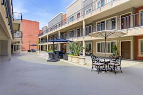 A patio with a table and chairs is surrounded by apartment buildings.