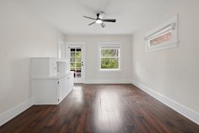 A room with a ceiling fan and a window.