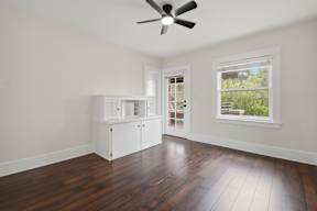 A room with a ceiling fan and a window.