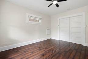 A room with a ceiling fan and a door.