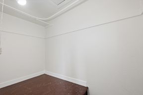 A room with a brown floor and white walls.