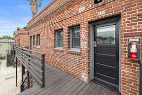 A red brick building with a black door and windows.