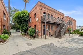 A red brick building with a staircase leading to the entrance.