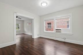 A room with a window and a wooden floor.