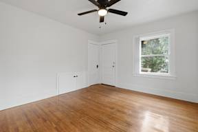 A room with a ceiling fan and a window.