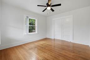 A room with a ceiling fan and a window.