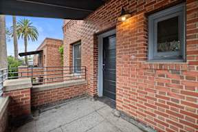 A balcony with a black door and a window.