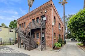 A red brick building with a staircase in front.