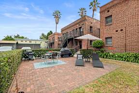 A patio with a table and chairs is surrounded by a brick wall.