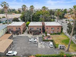 A parking lot with cars and a building in the background.
