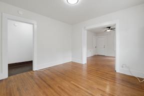 A room with wooden floors and a ceiling fan.