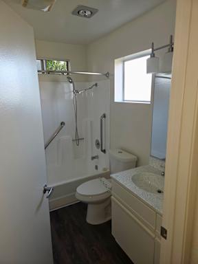 A white toilet is in a bathroom with a sink and a shower.