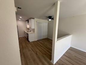 A room with a wooden floor and a ceiling fan.