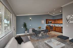 A modern living room with a grey sofa and a dining table set up.