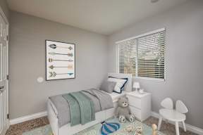 A child's bedroom with a white bed, a teddy bear, and a framed picture of arrows on the wall.