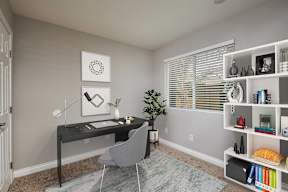 A room with a desk, chair, and bookshelf.