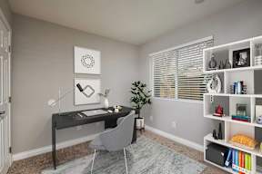 A room with a desk, chair, and bookshelf.