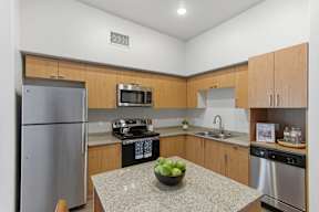 A kitchen with a refrigerator, stove, and oven.