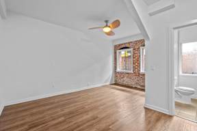 A room with a brick wall and wooden flooring.