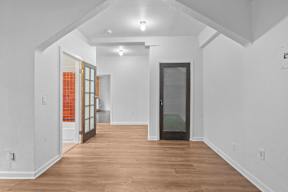 A room with a white wall and a wooden floor.