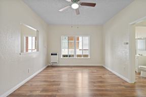 A room with a ceiling fan and a window with blinds.