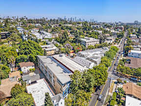 A cityscape with a clear blue sky and a mix of residential and commercial buildings.