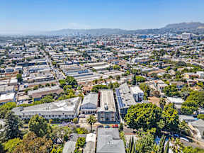 A cityscape with buildings and trees under a clear sky.