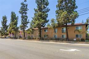 A row of houses with trees in front of them.