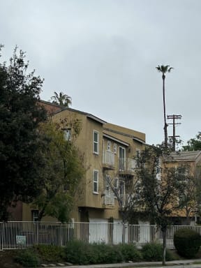 Fenced property around townhomes with attached garages and balconies at Serenata Townhomes in San Diego, California.