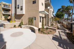 Front privacy fence, mailboxes and community space at Villa Grande Apartments in San Diego, California.