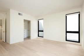 Bedroom with large windows, walk-in closet, and bathroom in apartment at 633 Palms Blvd. in Venice, California.