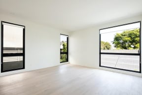 Bedroom with large windows and wood plank floor at 633 Palm Blvd. apartment in Venice, California.