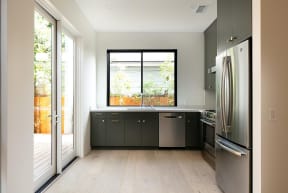 Kitchen with glass doors to the outside deck walkway and upscale appliances in apartment at 633 Palms Blvd. in Venice, California.