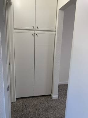 A white double door wardrobe in a room.