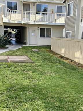 A small patch of grass in front of a building.