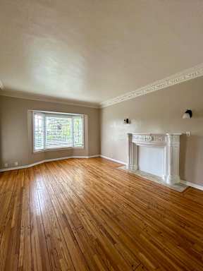 A room with wooden floors and a fireplace.