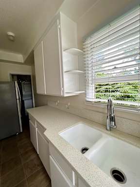 A kitchen with a sink and a refrigerator.