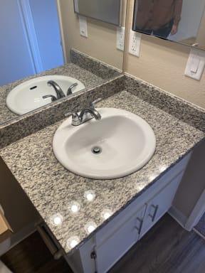 Bathroom sink with granite top and brushed nickle fixtures.