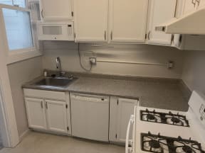 Gas range and white kitchen cabinets at 900 Taylor Street Apartments in San Francisco.