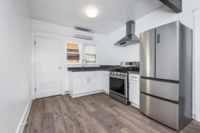 Kitchen with large refridgerator and gas range at 4141 Normal Avenue apartment homes in Los Angeles, California.