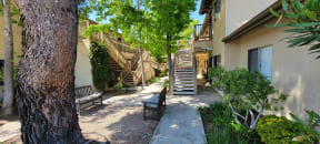 Plesant walkway with shaded benches between buildings at Sierra Heights Apartments.