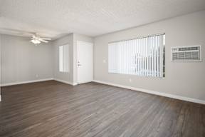 A room with wooden flooring and a ceiling fan.